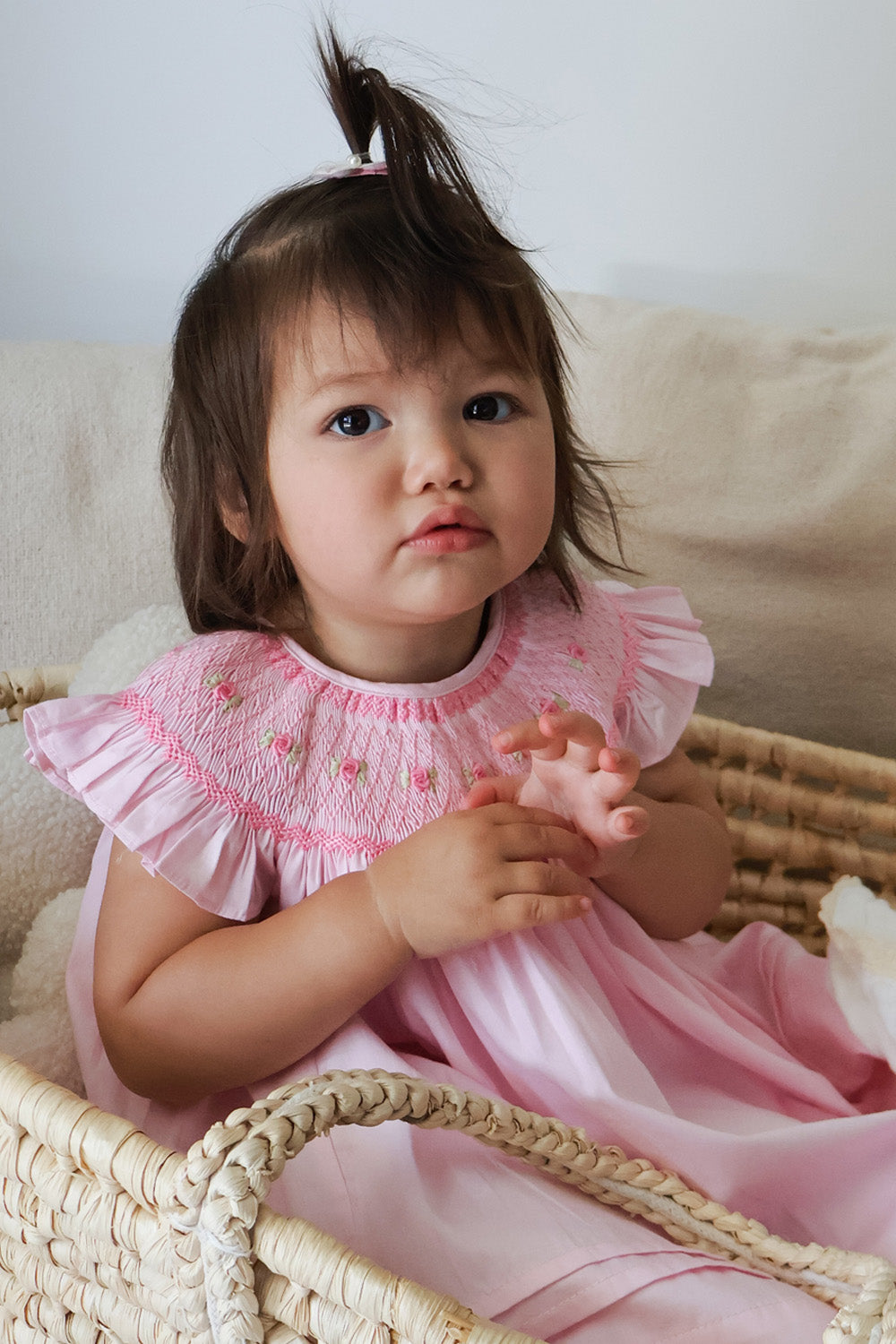 Girl in light pink smocked bishop dress