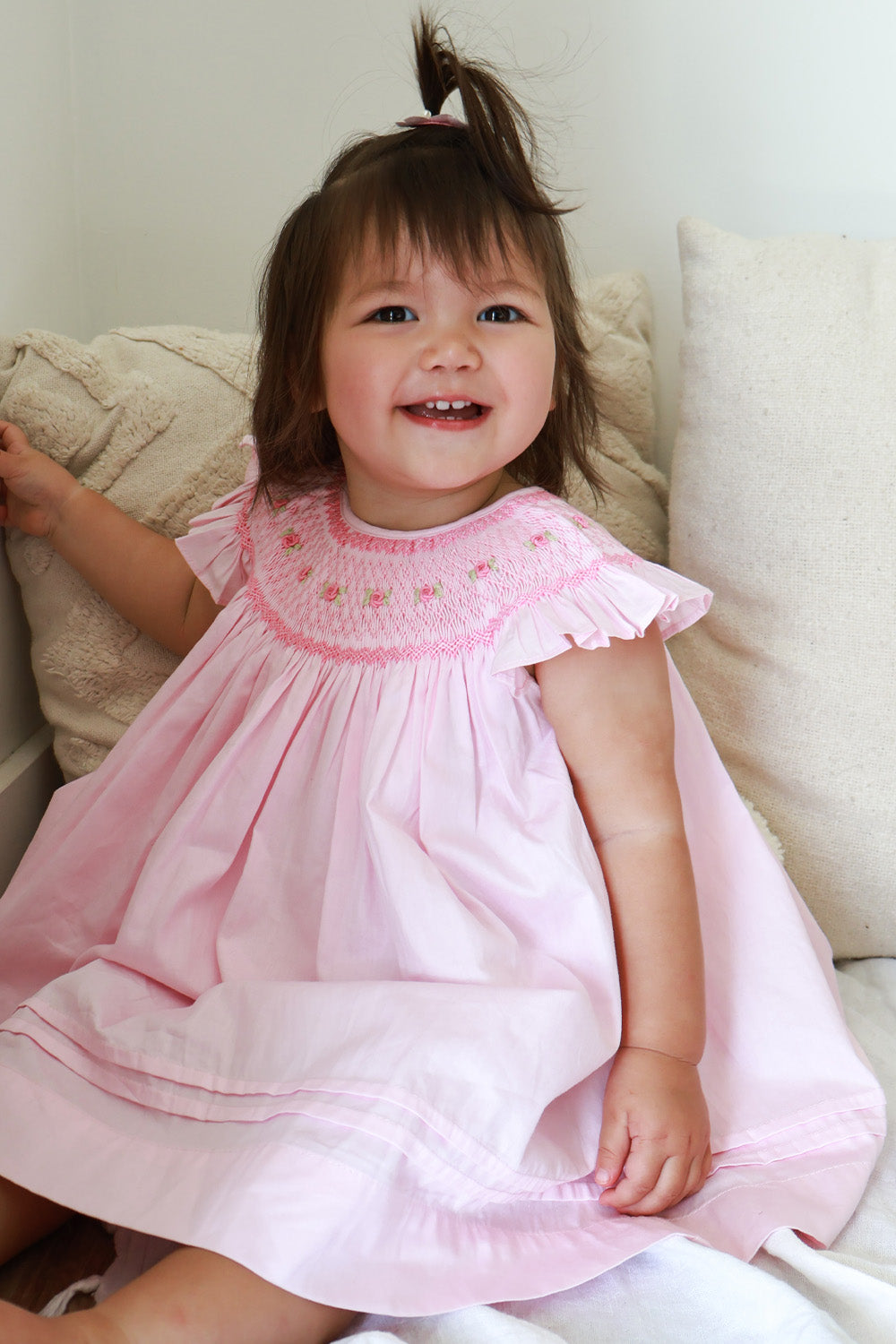 Toddler girl wearing Pink Rose hand smocked bishop dress with ruffled sleeves