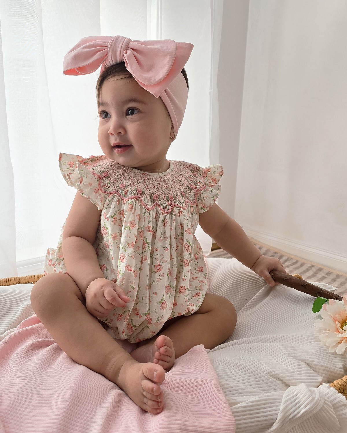 Baby girl wearing pink floral smocked bishop romper