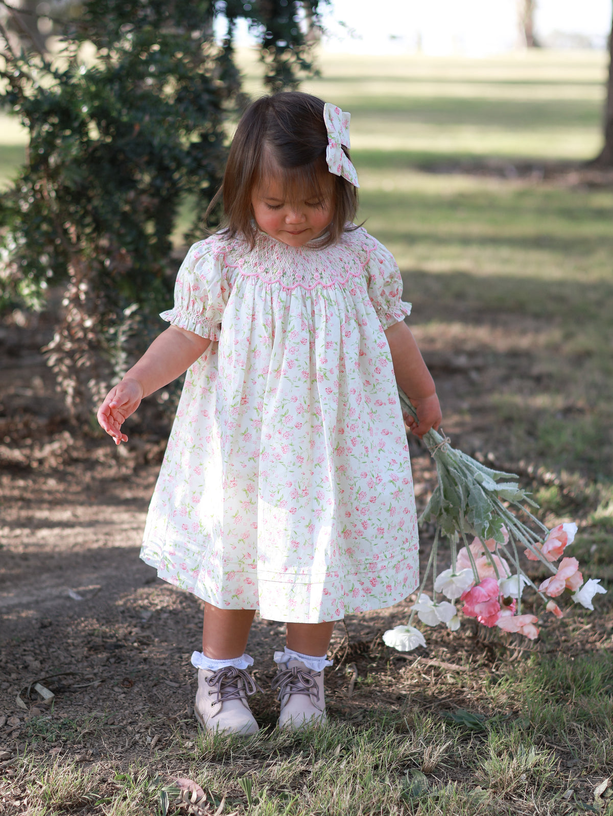 A toddler girl wearing a pink floral dress  